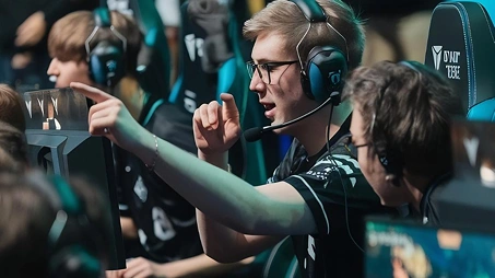 Een e-sportteam viert een overwinning tijdens een competitief gametoernooi, terwijl ze headsets dragen en achter gaming-pc's zitten.